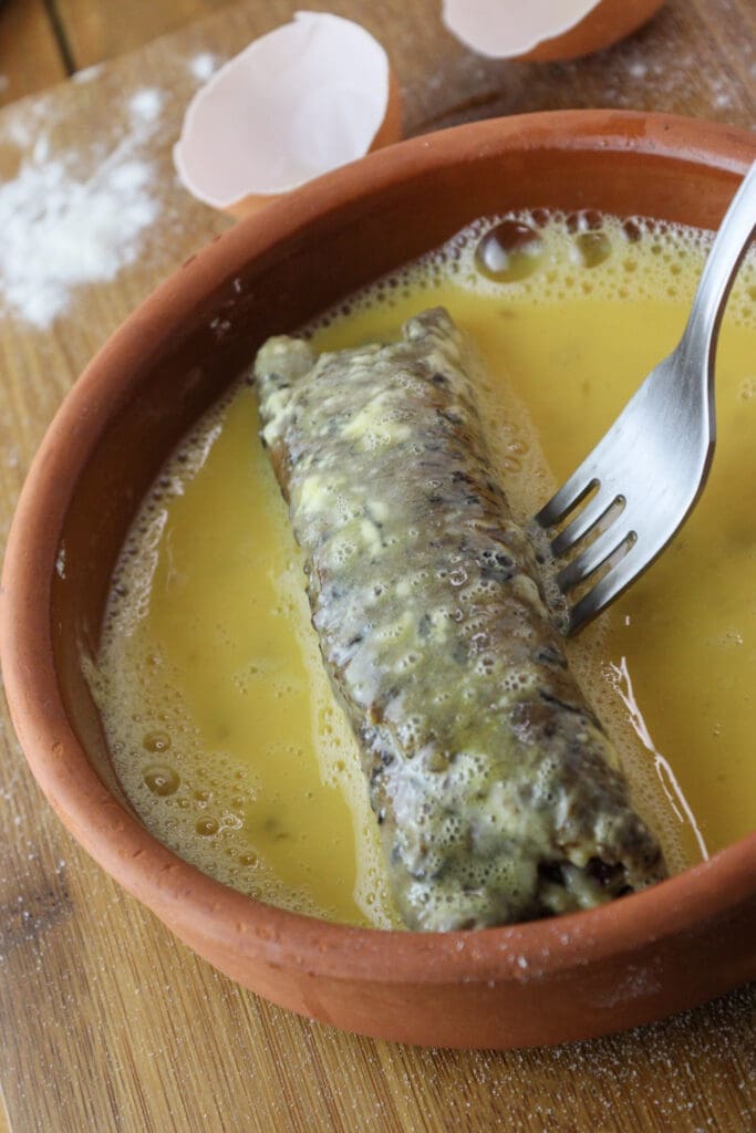 Dipping the rolls in eggs before coating with breadcrumbs.